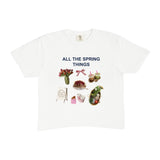 White t-shirt with spring-themed graphics and text on a white background
