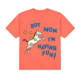 A coral orange short-sleeve crewneck t-shirt featuring a graphic of a white unicorn with yellow stars and the text 'BUT MOM I'M HAVING FUN!' in blue and white.