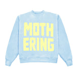 Light blue sweatshirt with yellow text 'MOTHERING' on a white background