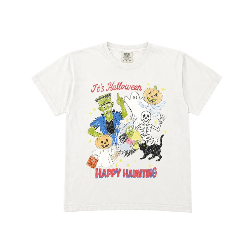 An off-white short-sleeve t-shirt with a colorful Halloween graphic on the front, featuring cartoon characters like Frankenstein, a skeleton, a black cat, and pumpkins, with the text 'It's Halloween' and 'HAPPY HAUNTING'.