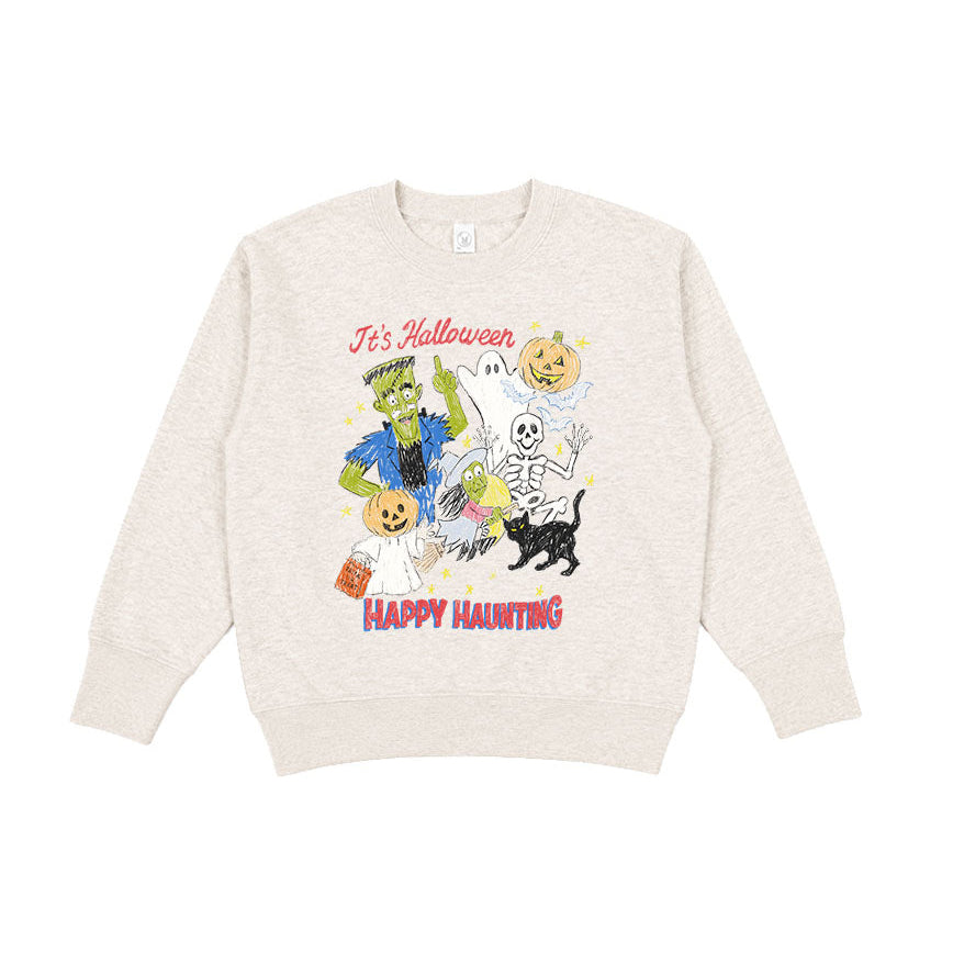 A cream-colored crewneck sweatshirt featuring a colorful graphic print of Halloween characters, including a skeleton, a cat, a pumpkin, and a zombie, with the text 'It's Halloween' and 'Happy Haunting'.