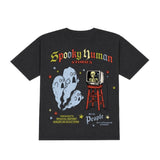 A black short-sleeve graphic t-shirt featuring a vintage-style horror design with the text 'Spooky Human Stories' and illustrations of a ghost, a television, and a red stool.