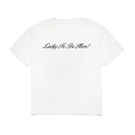 White t-shirt with 'Lucky To Be Here!' text on a white background