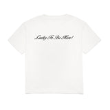 White t-shirt with 'Lucky To Be Here!' text on a white background