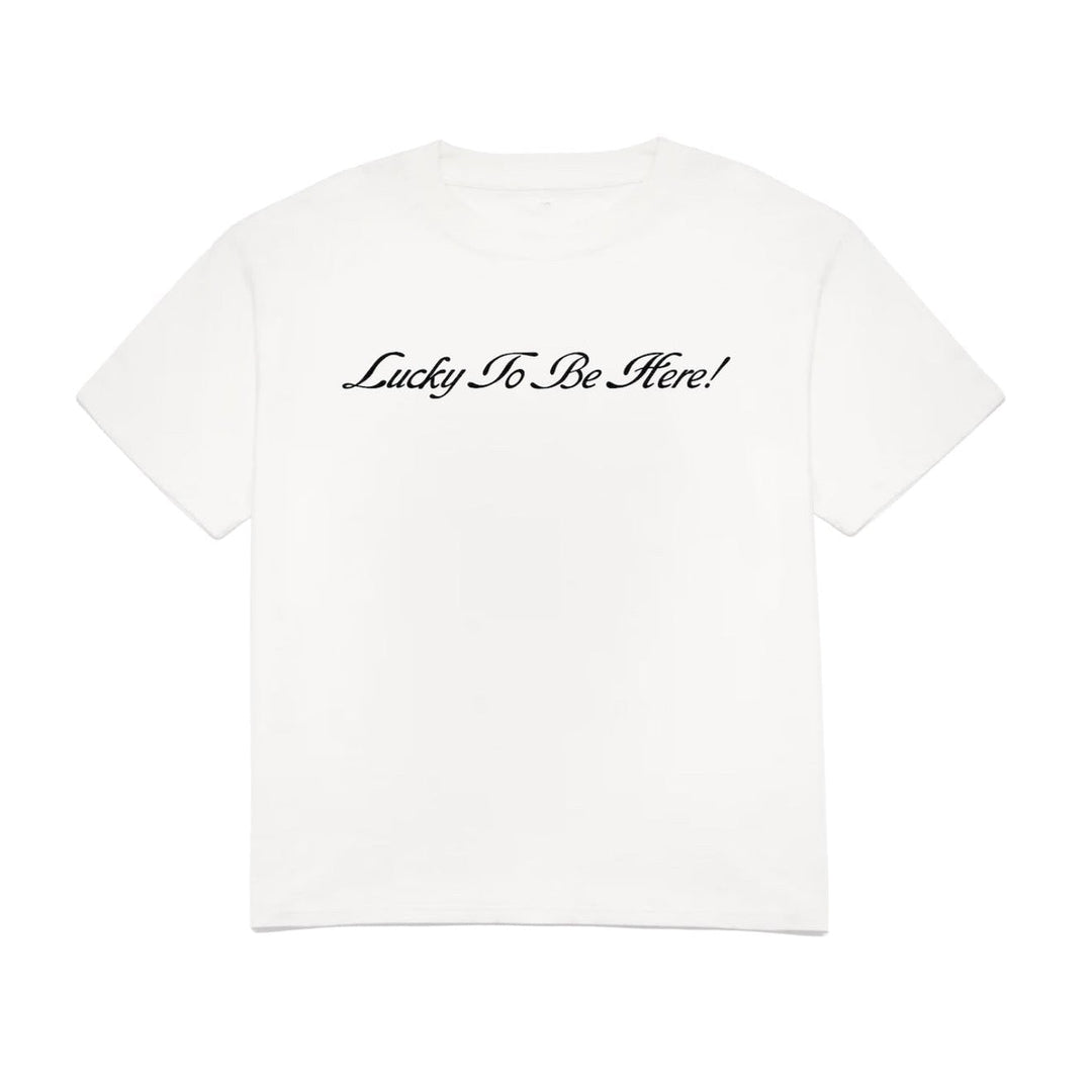 White t-shirt with 'Lucky To Be Here!' text on a white background
