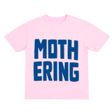 Pink t-shirt with blue text 'MOTHERING' on a white background