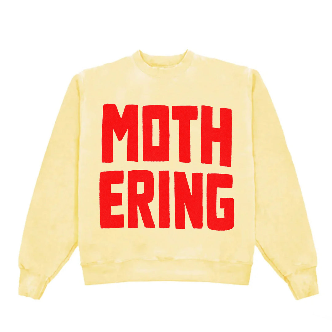 Yellow sweatshirt with red text 'MOTHERING' on a white background