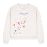 White sweatshirt with floral designs and text on a white background