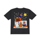 A black short-sleeve crewneck t-shirt featuring a colorful Halloween-themed graphic print on the front. The graphic depicts cartoon characters dressed as a cat, pumpkin, ghost, and witch under a full moon and stars, with a pumpkin sign reading 'TRICK TREAT'.